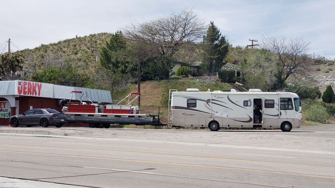 Large motorhome pulling a very large pontoon boat