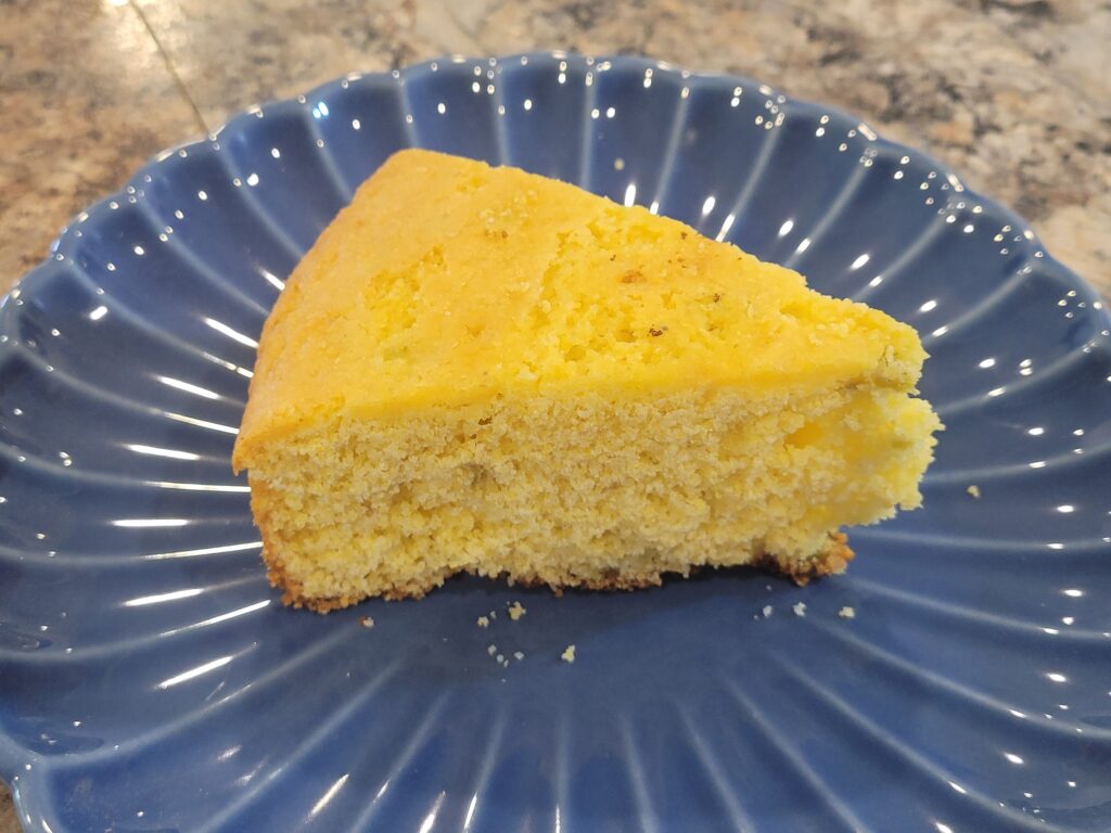 A slice of homemade Southern cornbread made with Jiffy Corn Muffin Mix served on a blue plate.