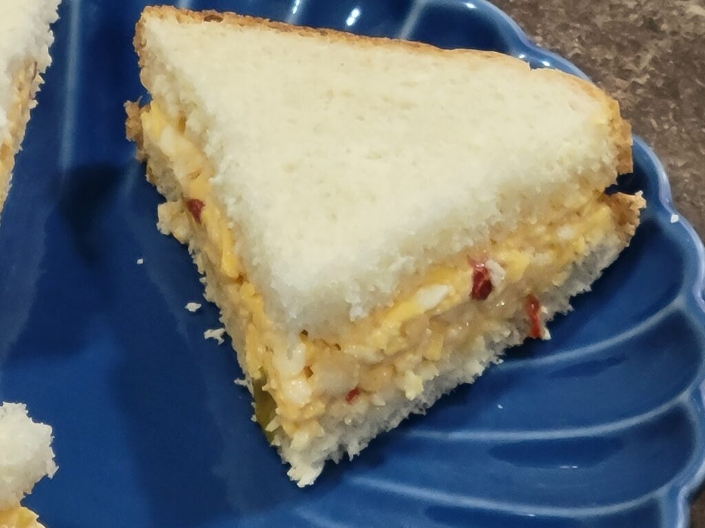 Southern pimiento cheese sandwich made with cheddar cheese and pimientos on soft white bread